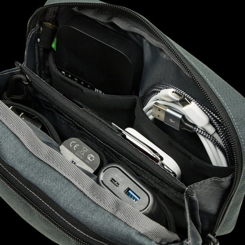 The Condor Tech Pouch features zippered compartments to organize tech accessories like cables, chargers, a power bank, and various gadgets.